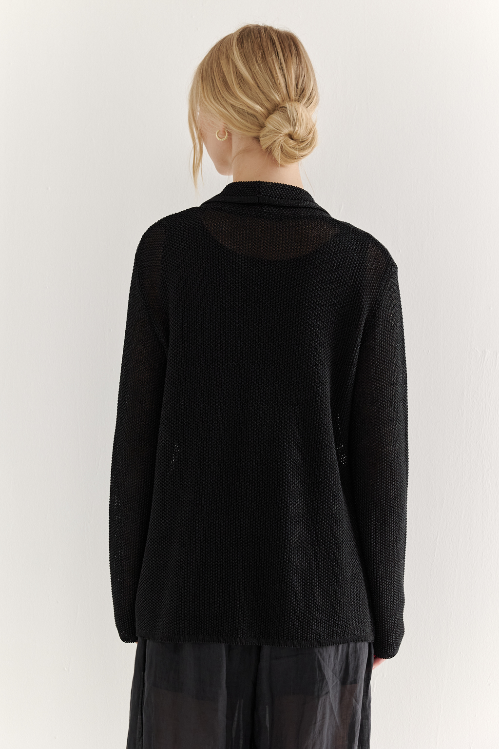 Жакет полуприлегающего силуэта черного цвета из вязаного трикотажа, в составе которого вискоза и хлопок. Плотная скрутка нити образует упругое, но в то же время дышащее полотно. Цельно вязаные лацканы элегантно переходят в воротник, обрамляя вырез. Прямые рукава полной длины завершают лаконичный силуэт. Этот жакет станет изысканным дополнением к непринужденному городскому образу.
