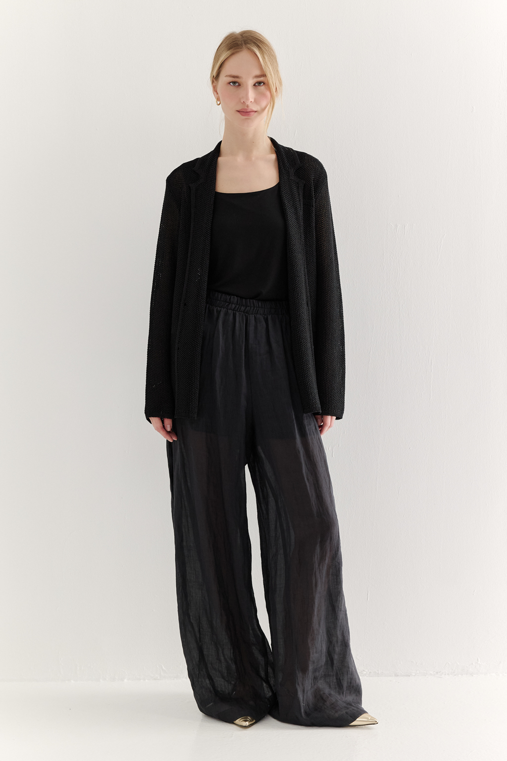 Жакет полуприлегающего силуэта черного цвета из вязаного трикотажа, в составе которого вискоза и хлопок. Плотная скрутка нити образует упругое, но в то же время дышащее полотно. Цельно вязаные лацканы элегантно переходят в воротник, обрамляя вырез. Прямые рукава полной длины завершают лаконичный силуэт. Этот жакет станет изысканным дополнением к непринужденному городскому образу.