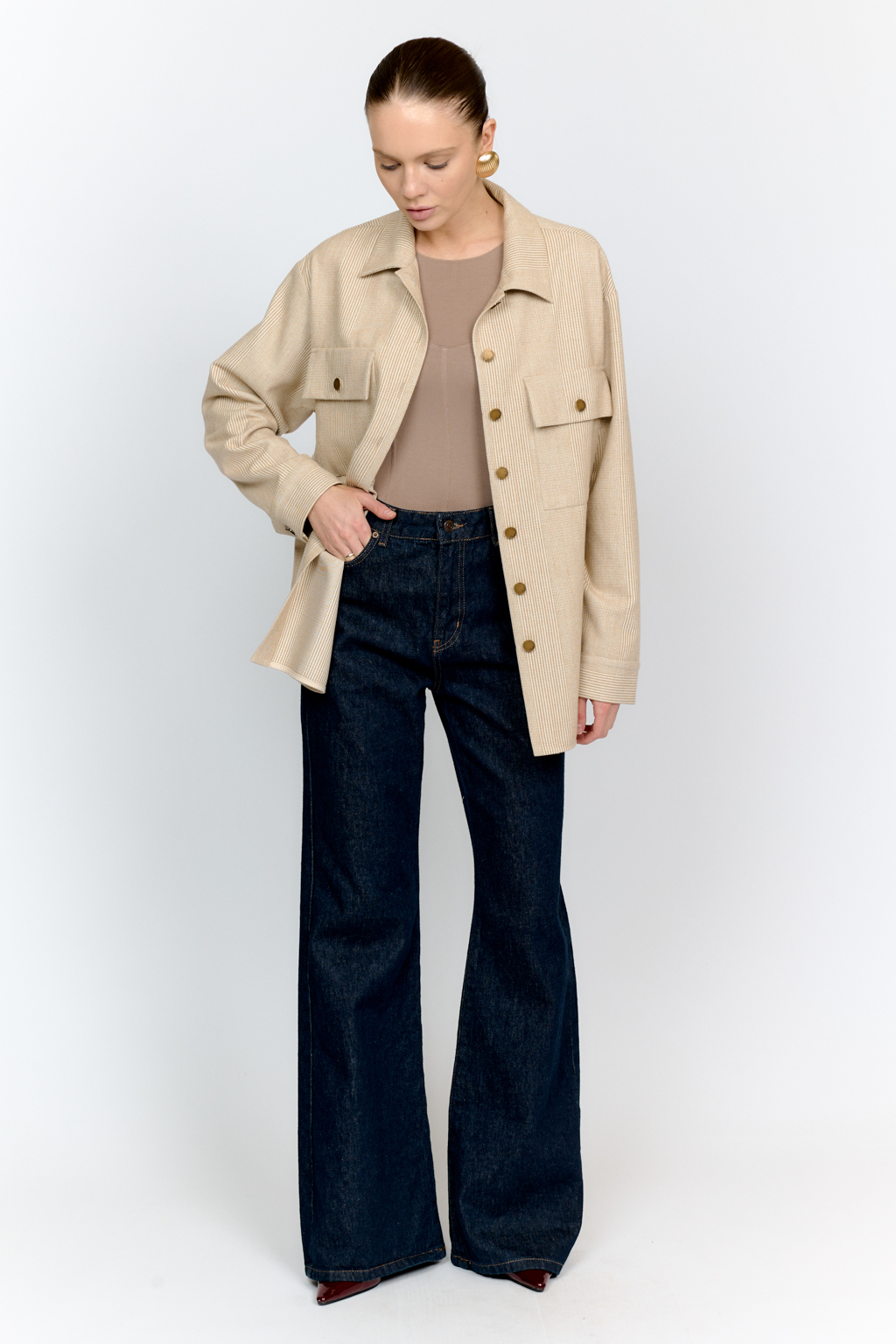 Рубашка свободного кроя с накладными карманами и застежкой на металлические пуговицы-болты из клетчатой костюмной ткани с peach-эффектом идеальна как для многослойных образов с футболками и водолазками, так и в качестве самостоятельной единицы.