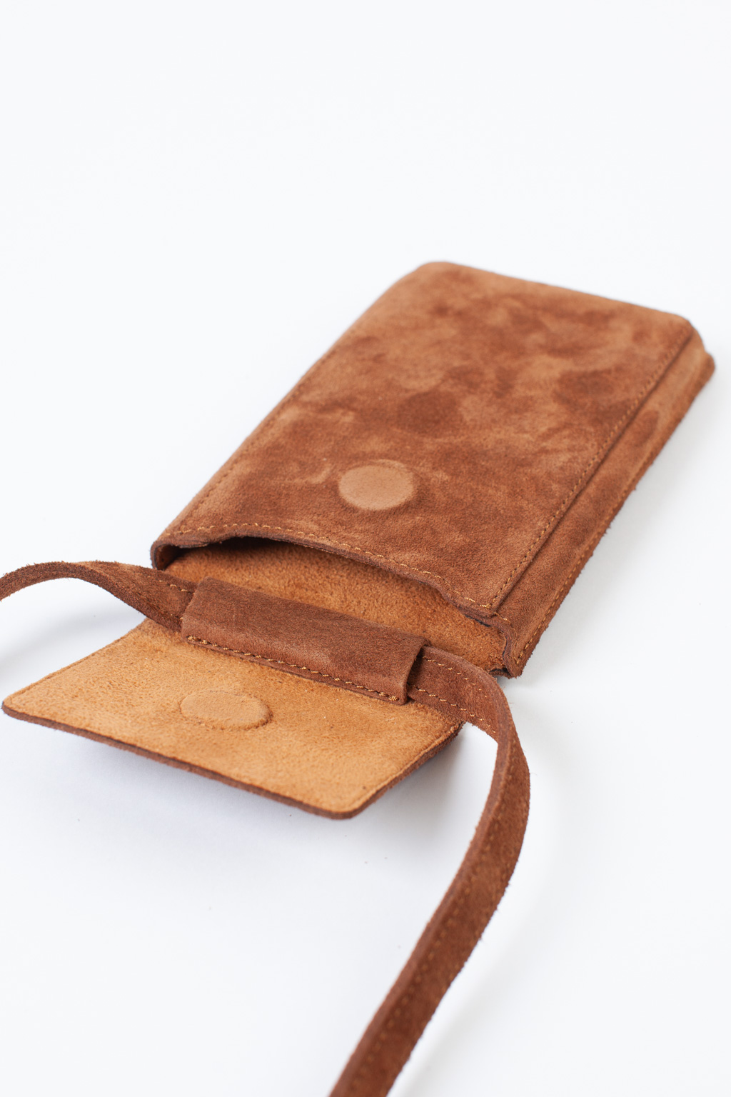 Стильный аксессуар из натуральной замши надёжно защитит Ваш гаджет от ударов и других внешних воздействий. Оснащена основным отделением для смартфона и разнообразных мелочей, а также двумя карманами для банковских карт и визиток. Сумка имеет регулируемый ремешок. Размеры: 17,5*10,3 см