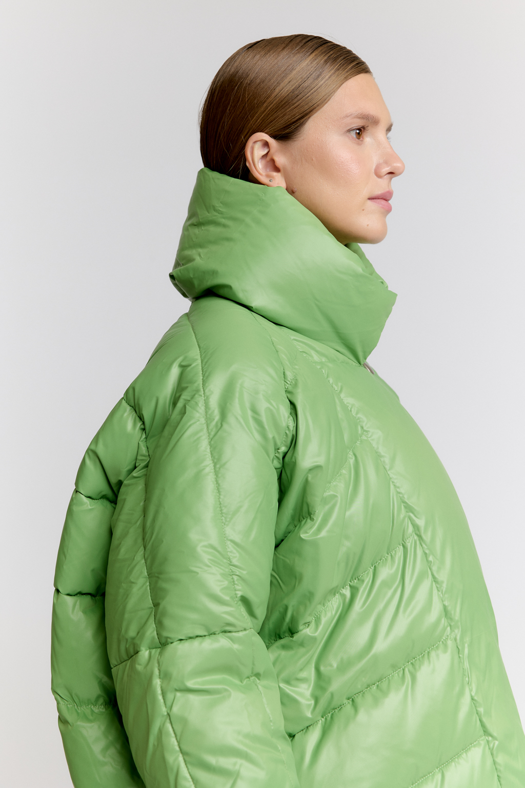 Пуховик оверсайз силуэта со спущенным плечом и высоким воротником стойкой в цвете зеленой мяты. Ассиметричная застежка на магниты и пуговицу.Длина до середины бедра.