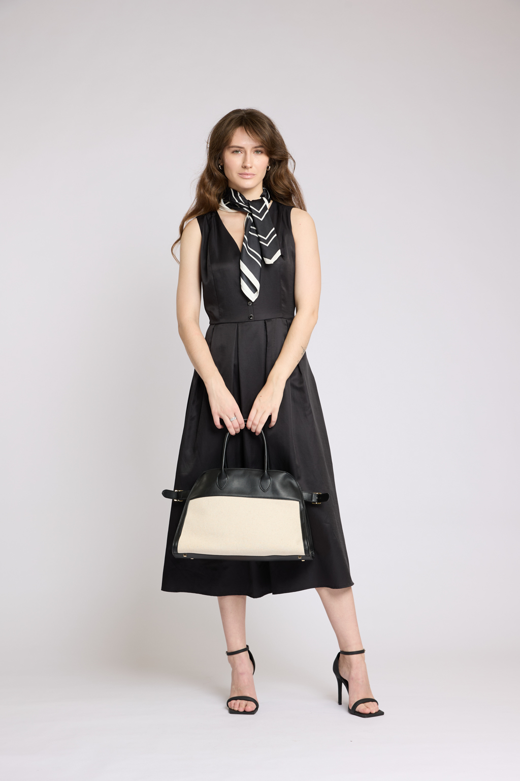 Платье длины миди с V-образным вырезом с декоративными пуговицами. Юбка пышная со складками. По бокам карманы.