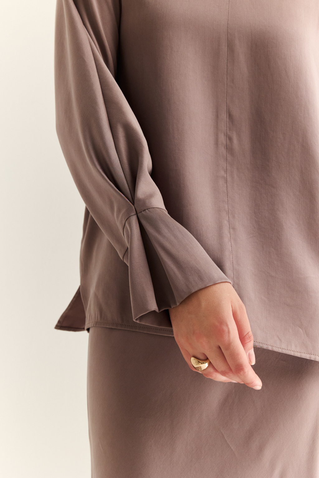 Блуза с цельнокроеными рукавами со складкой по манжету и V-образным вырезом по спинке.