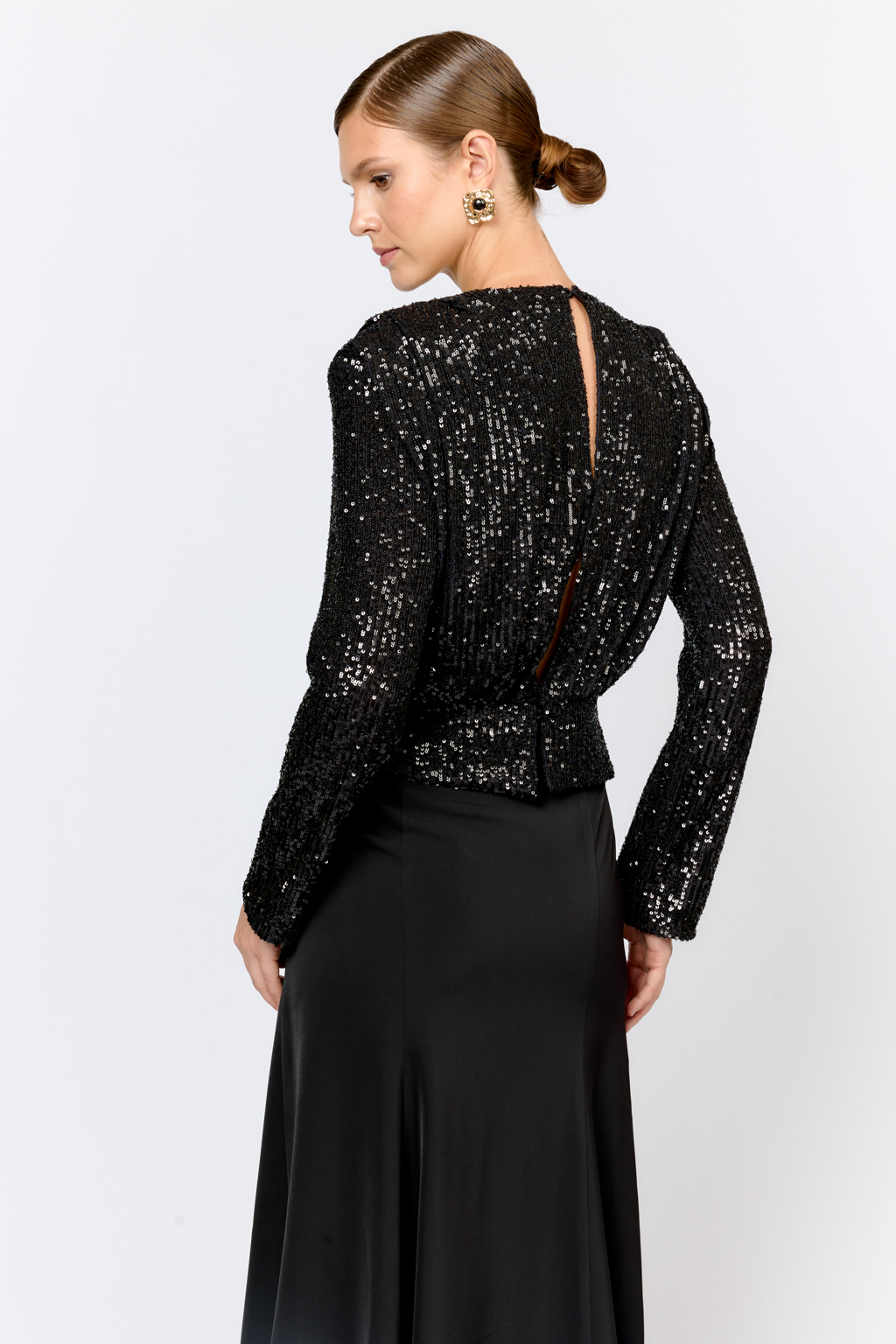 Праздничная блуза с мелкими глянцевыми пайетками с расширенной линией плеч и приталенного силуэта. По линии талии кокетка с застежкой сзади на потайные пуговицы. Ткани из полиэстера практичен в уходе, держат форму и устойчивы к сминанию. Преимущества ткани: умеренно блестящая, привлекающая  внимание ткань, для создания  эффектных образов. Пайетки придают изделиям уникальный блеск и сияние, делая их запоминающимися и праздничными.  Основа  - мягкая пластичная сетка, что делает изделие комфортным.