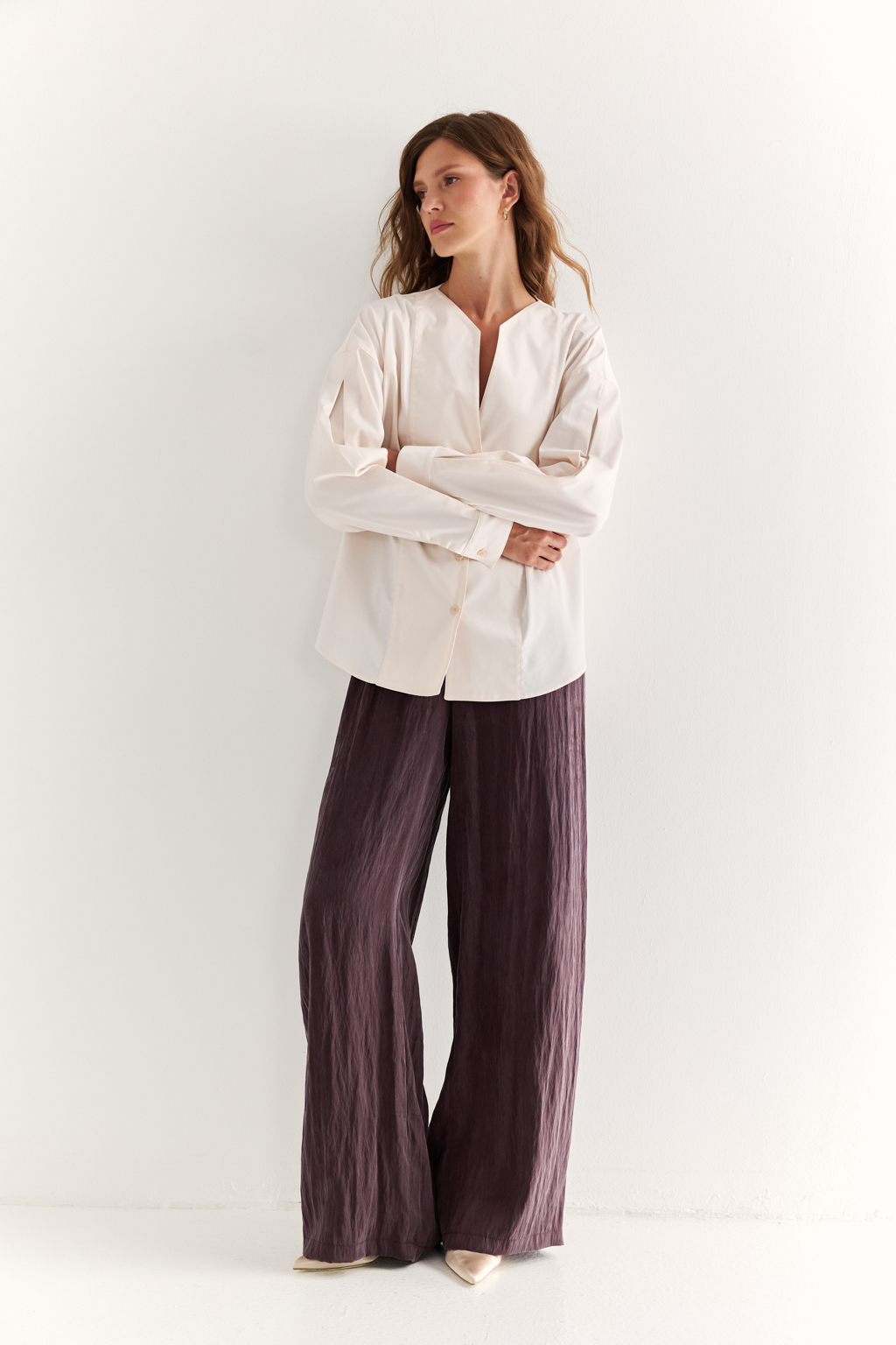 Блуза с V-вырезом: нежность в современном ритме. Эта блуза сочетает в себе деликатность форм и продуманную простоту. Глубокий V-образный вырез визуально вытягивает силуэт, а мягкие линии кокетки и рукавов добавляют романтичности. Объёмные рукава с манжетами и аккуратная застёжка на пуговицы завершают образ с лёгкой винтажной ноткой. Идеально смотрится в паре с юбками на высокой талии, широкими брюками или под жилет. Благодаря универсальному дизайну легко вписывается как в деловой, так и в вечерний гардероб. Лёгкость, которая подчёркивает внутреннюю силу.