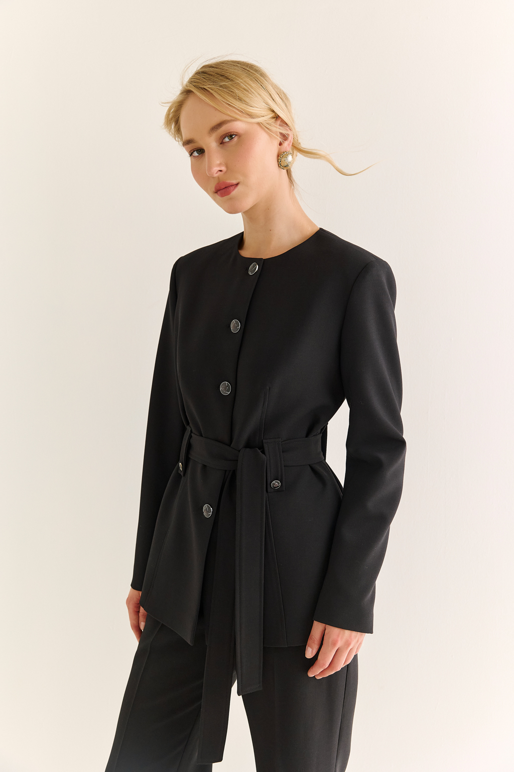 Жакет с круглым вырезом: лаконичная форма, элегантная подача. Этот жакет — воплощение утончённой сдержанности. Круглый вырез придаёт модели мягкость и графичность, а прямой силуэт и выверенные пропорции делают её универсальной основой гардероба. Благодаря отсутствию лацканов образ выглядит свежо и современно, а акцент на линии талии — при помощи пояса или рельефов — подчёркивает фигуру. Идеален как в деловом комплекте с юбкой или брюками, так и в расслабленных стилизациях с джинсами или платьем. Современная классика для тех, кто выбирает чистоту линий и уверенность в деталях.