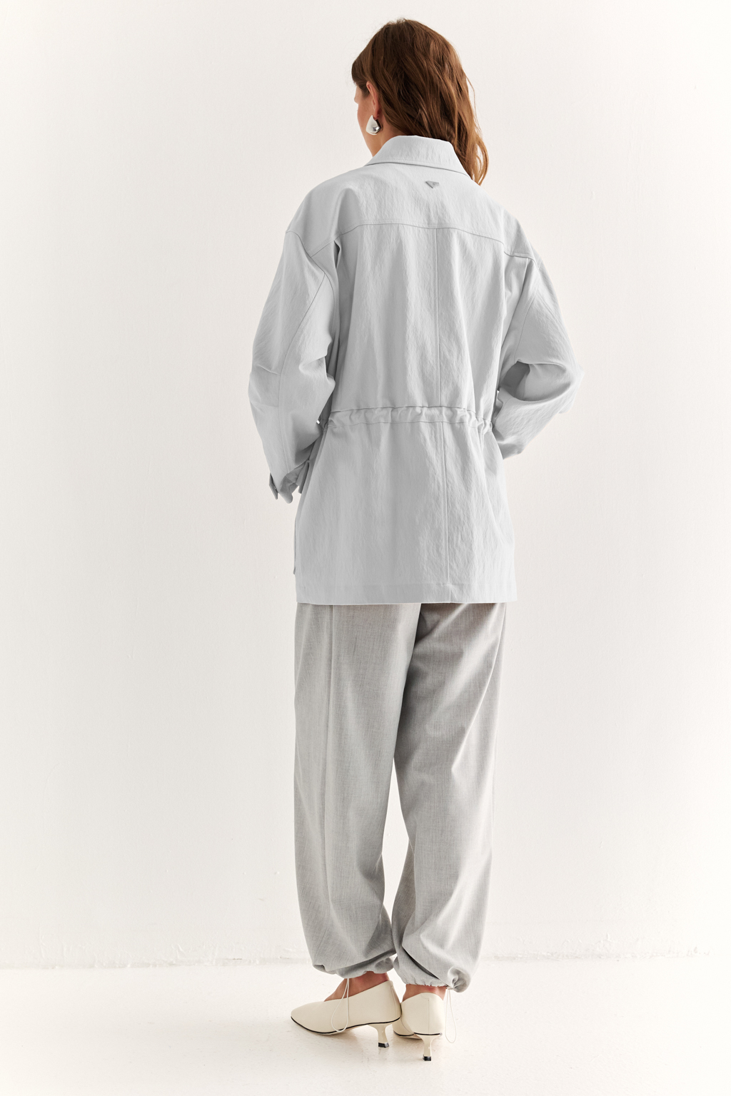 Куртка прямого силуэта длиной до бедер и с кулисой по талии. Воротник рубашечный, застежка под планкой. По полочке накладные карманы-портфели.