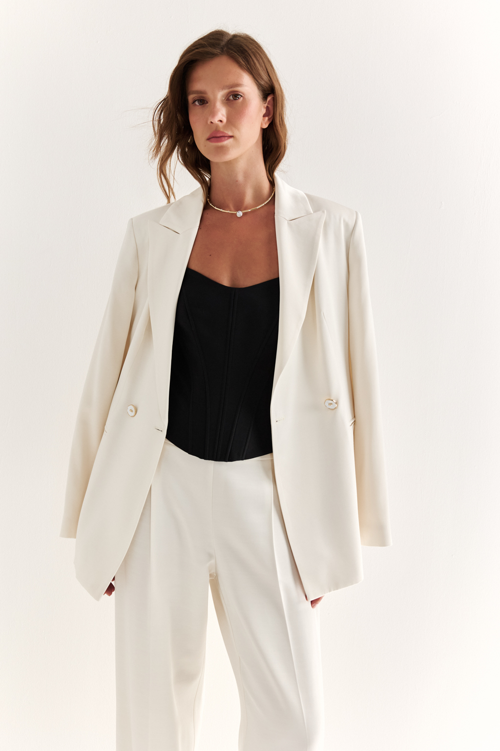 Двубортный жакет: классика в современной геометрии. Удлинённый двубортный жакет — это база, которая говорит о статусе без слов. Чёткие плечи, графичный крой и острые лацканы формируют уверенный, собранный образ. Рельефы по спинке и бокам подчёркивают силуэт, обеспечивая идеальную посадку, а карманы добавляют практичности и сдержанного акцента. Идеален в паре с классическими брюками, юбкой-карандашом или джинсами. Работает как в деловом комплекте, так и в вечерней стилизации. Современная структура с уважением к традиции.