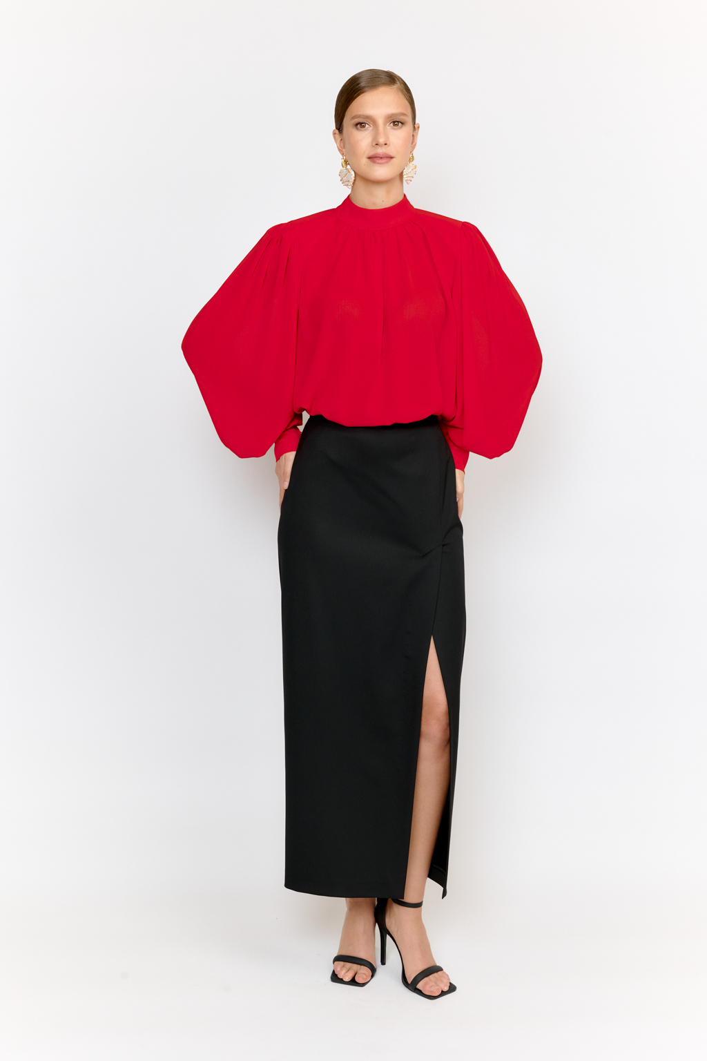 Блуза в стиле Бохо, объемного силуэта с воротником-стойка и пышными рукавами на манжетах. Преимущества ткани: легкость и воздушность, создающая эффект невесомости. Практичность и универсальность для многослойных комплектов. Полиэстеровая ткань сохраняет насыщенность цвета  и форму даже при активной носке.