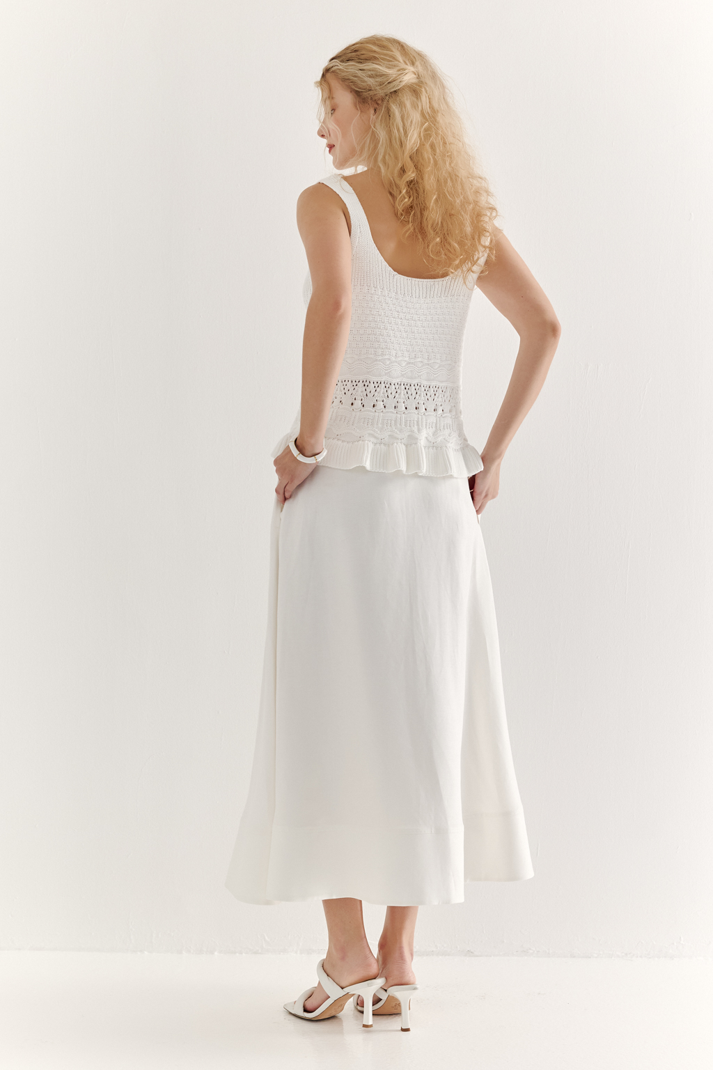 Юбка-миди, с силуэтом полусолнце, из уникальной ткани – 100% льняного твила белого цвета с эффектом air wash, является must-have наступающего сезона. Расширяющийся книзу силуэт дополнен притачным бордюром по нижнему краю, что подчеркивает женственность образа. Юбка имеет подкладку, узкий пояс и застежку на потайную молнию в боковом шве. Предлагаем носить эту юбку с льняными жакетами, а так же вязанными трикотажными топами.