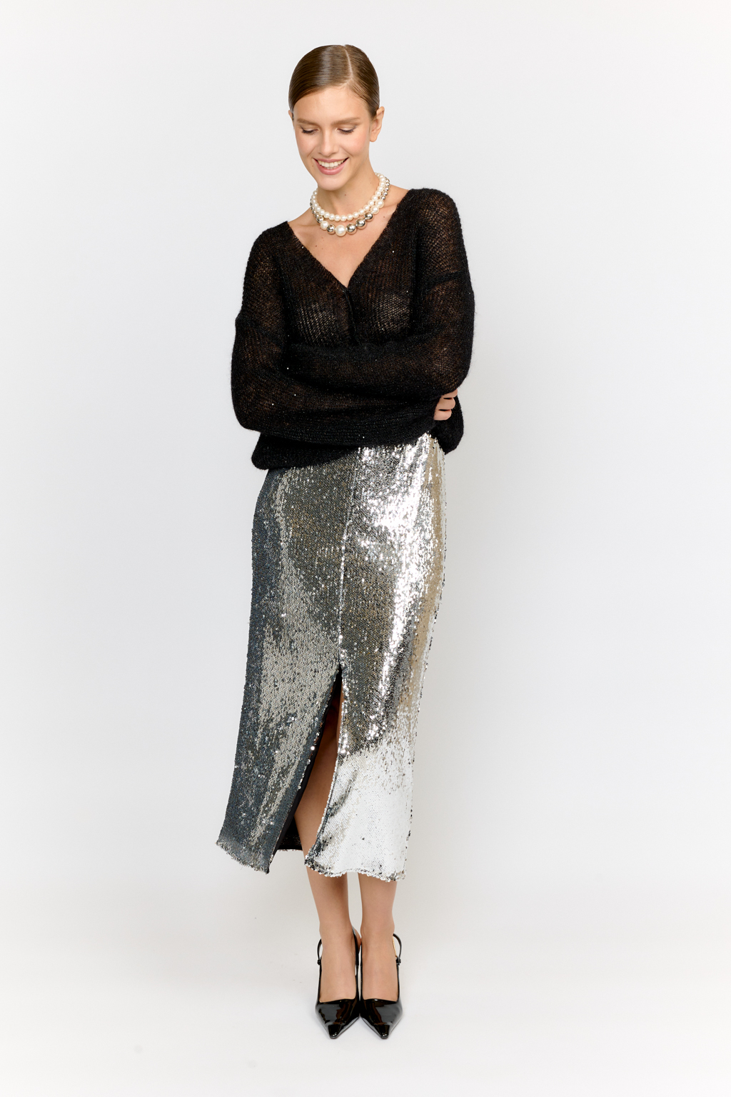 Кардиган с центральной застежкой на пуговицы, V-образной горловиной и длинным рукавом.  Модель свободного силуэта в глубоком черном  оттенке из воздушной пряжи с шерстью и мохером с деликатными мелкими пайетками, придающими легкое сияние. Кардиган очень теплый, несмотря но свою трендовую транспарентность и легкость, благодаря мохеру в составе. Шерсть так же обеспечивает естественную терморегуляцию и уют. Такой кардиган будет выигрышно смотреться в образах с  брюками и юбками из коллекции, а так же дополнит образы с платьями на бретелях или платьем-бандо.