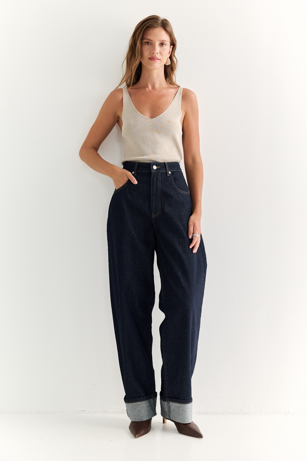 Трендовые джинсы свободного кроя из плотного темно-синего денима. Отлично сочетаются как с расслабленными трикотажными джемперами, так и с женственными блузами - для повседневных и офисных образов.