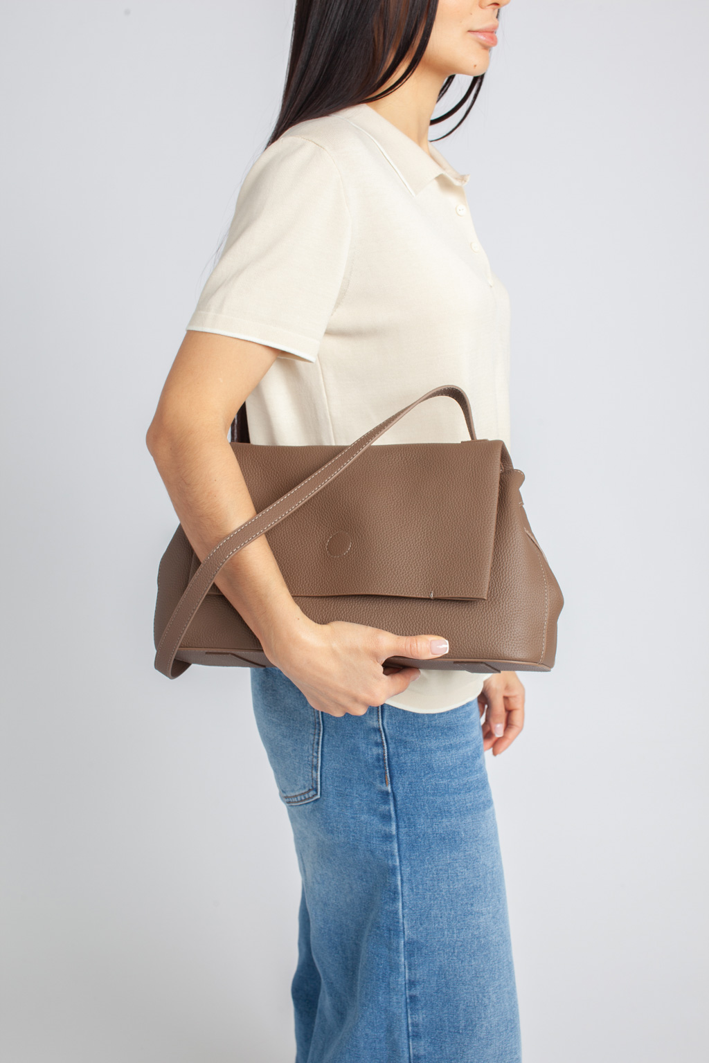 Стильная сумка на плечо в коричневом оттенке выполнена из натуральной зернистой кожи. Сумка закрывается клапаном на магнитную кнопку и на молнию. Внутри 2 отдела, разделенных средником с карманом на молнии. На внутренних боковых стенках есть 3 кармана для мелочей: 2 открытых и на молнии. На тыльной стороне предусмотрен карман быстрого доступа на молнии. В комплекте два съемных ремня для комфортного ношение аксессуара в руке и на плече , ширина 1,5 см и 2,5 см.