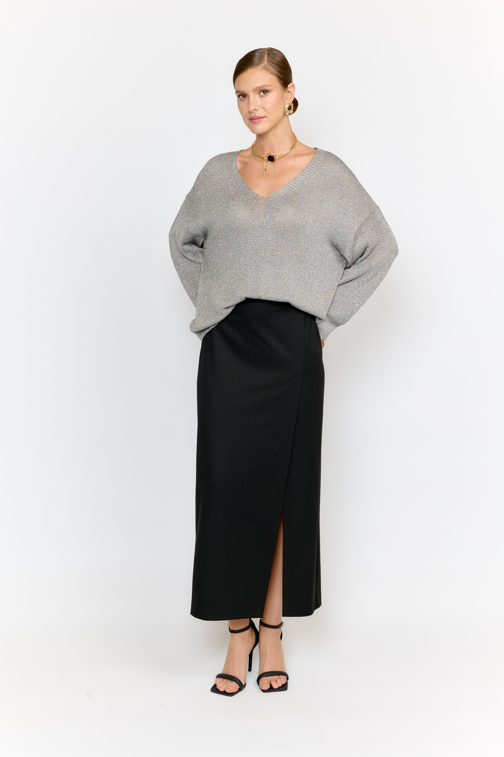 Модель джемпера с V-образным  вырезом горловины и свободным кроем выполнена из премиальной пряжи с вискозой в составе. Металлизированное волокно придает пряже  мерцание. Мягкие ниспадающие линии джемпера красиво драпируют фигуру. Базовая по крою модель, выглядит уникальной  благодаря эффектному металлизированному блеску и серо-серебряному цвету пряжи. Элегантный силуэт с длиной выше бедер и изящным V-образным вырезом подчеркивает женственность и создает безупречный образ.