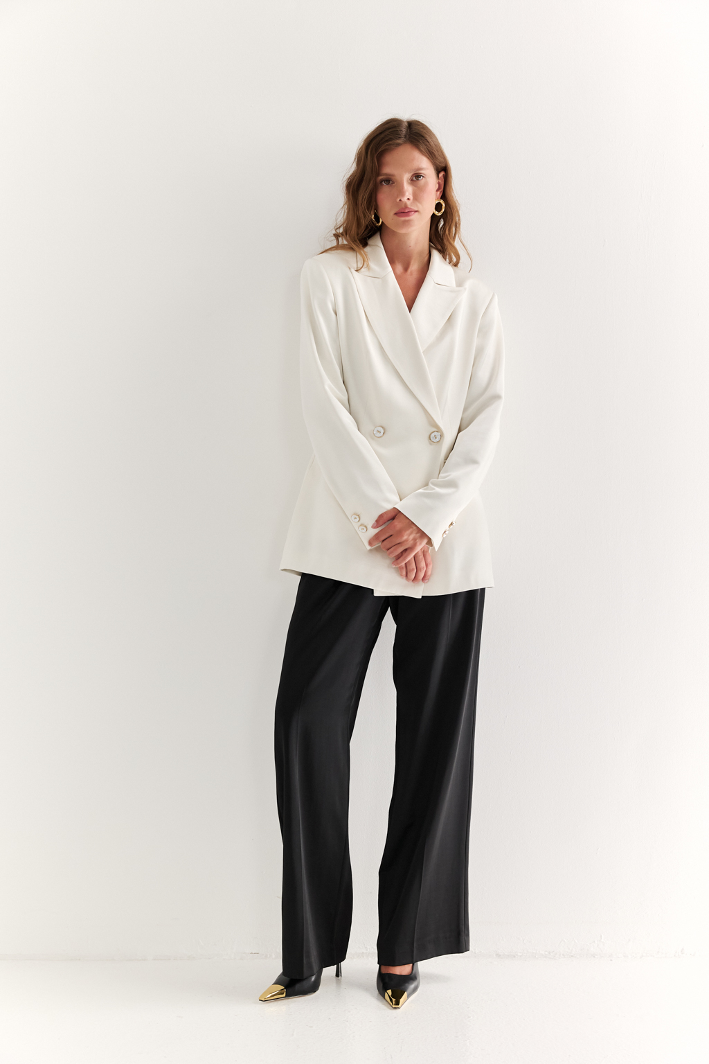 Двубортный жакет: классика в современной геометрии. Удлинённый двубортный жакет — это база, которая говорит о статусе без слов. Чёткие плечи, графичный крой и острые лацканы формируют уверенный, собранный образ. Рельефы по спинке и бокам подчёркивают силуэт, обеспечивая идеальную посадку, а карманы добавляют практичности и сдержанного акцента. Идеален в паре с классическими брюками, юбкой-карандашом или джинсами. Работает как в деловом комплекте, так и в вечерней стилизации. Современная структура с уважением к традиции.