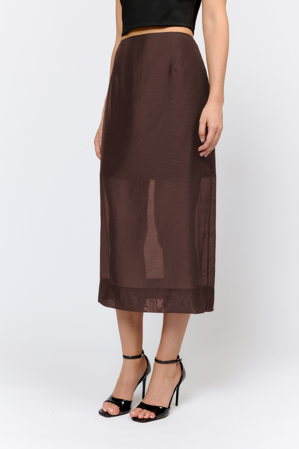 Юбка прямого кроя с цельнокроеным поясом и разрезом сзади в среднем шве. Модель длины миди снаружи из легкой полупрозрачной ткани с жемчужным переливом с содержанием шелка, внутри на отлетной подкладке длины мини из плотной ткани с вискозой. По низу юбка с широким подгибом. Застегивается на потайную молнию в боковом шве.  Модель юбки идеальна для создания  утонченных образов в сочетании с жакетами, блузами, топами. Шёлк в составе ткани придает благородный блеск и шелковистость ткани. Тенсель, экологичный материал, обеспечивает гигроскопичность, легкость, прочность и устойчивость к механическим повреждениям.