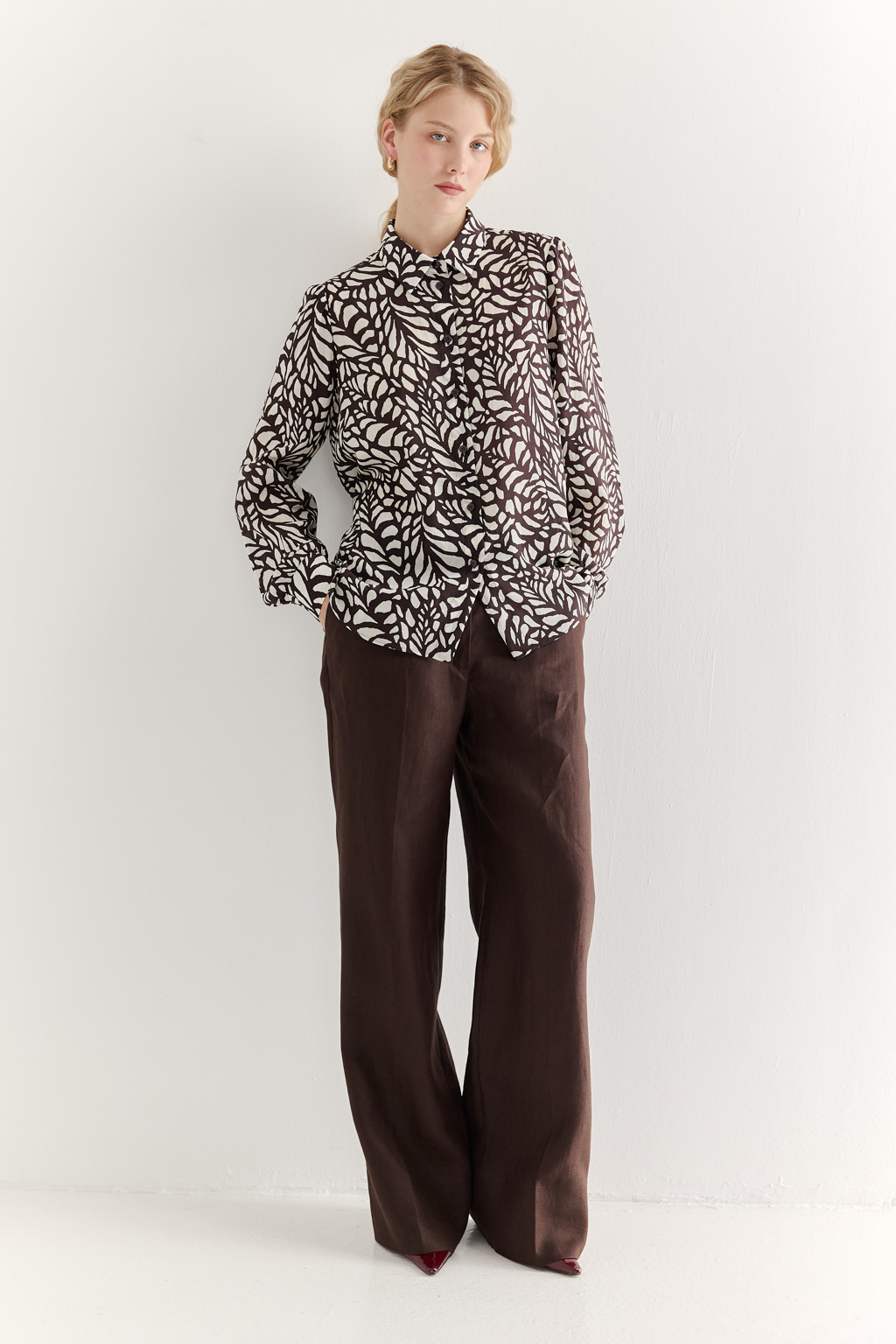 Блуза из легкой блузочной ткани с эффектом шелка со стилизованным растительным принтом в шоколадно-молочной гамме. Комфортная блуза имеет рубашечный воротник со стойкой, длинный рукав с манжетами, застёгивается на пуговицы.