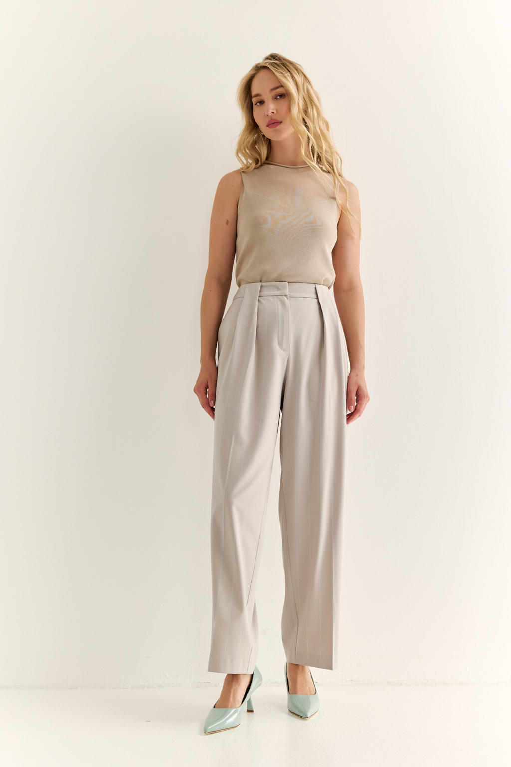 Брюки со складками: актуальный силуэт и комфорт с характером. Эти брюки с высокой посадкой и мягкими складками от талии — отличный баланс между классикой и современностью. Складки добавляют объёма и свободы в движении, формируя красивую линию бедра, а зауженные книзу штанины подчёркивают динамичность образа и визуально стройнят. Прорезные карманы сзади, шлёвки под ремень и точный крой делают модель универсальной: носите с жакетами, блузами или базовыми топами — от офиса до неформальных выходов. Гармония объёма и структуры. Брюки, которые работают на вашу фигуру.