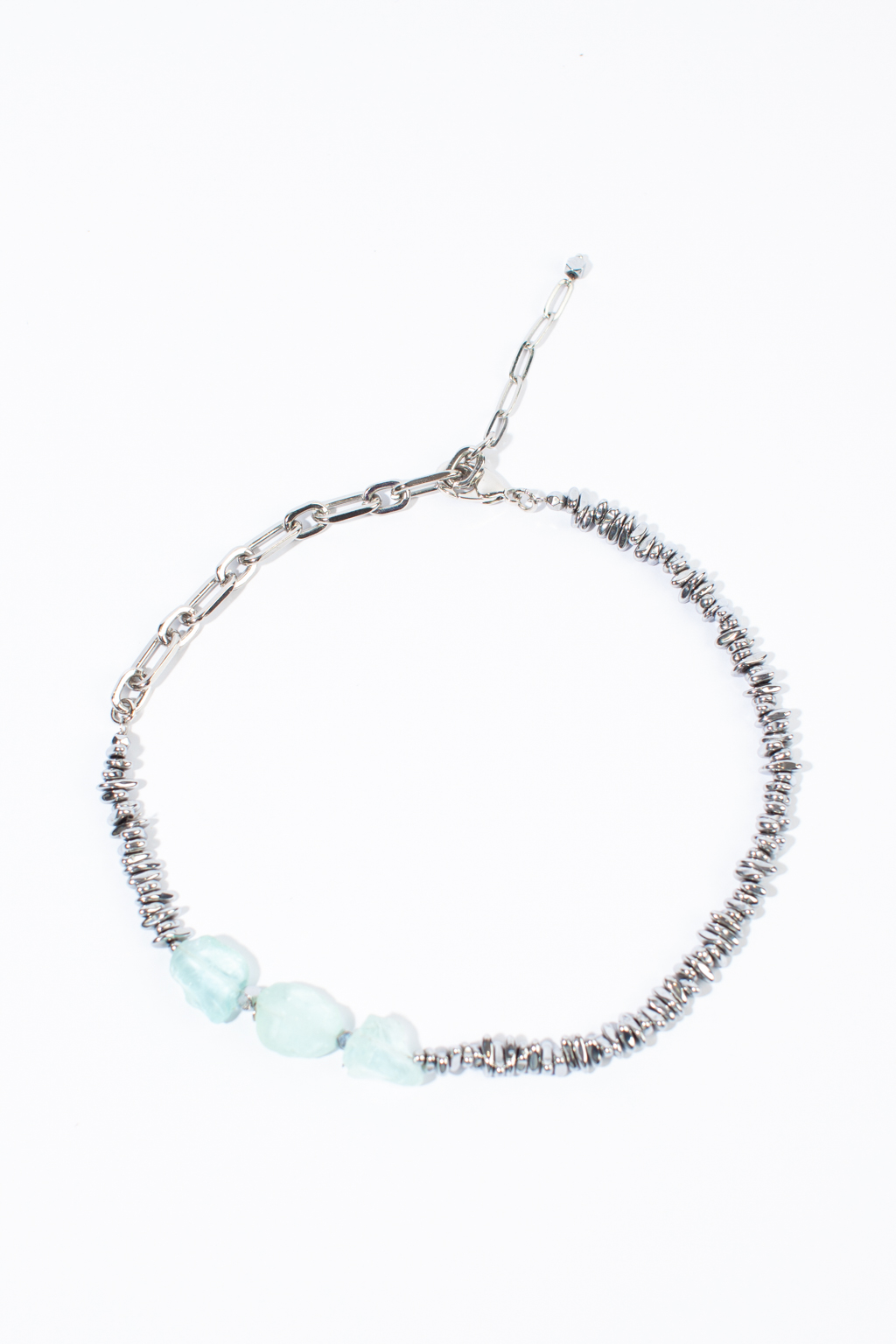 Дизайнерское колье выполнено с использованием акакварца и благородного гематита. Изделие можно носить как в расслабленном виде, так и в виде чокера за счет крупных дополнительных звеньев. Фурнитура выполнена из гипоаллергенного сплава со стойким гальваническим покрытием.