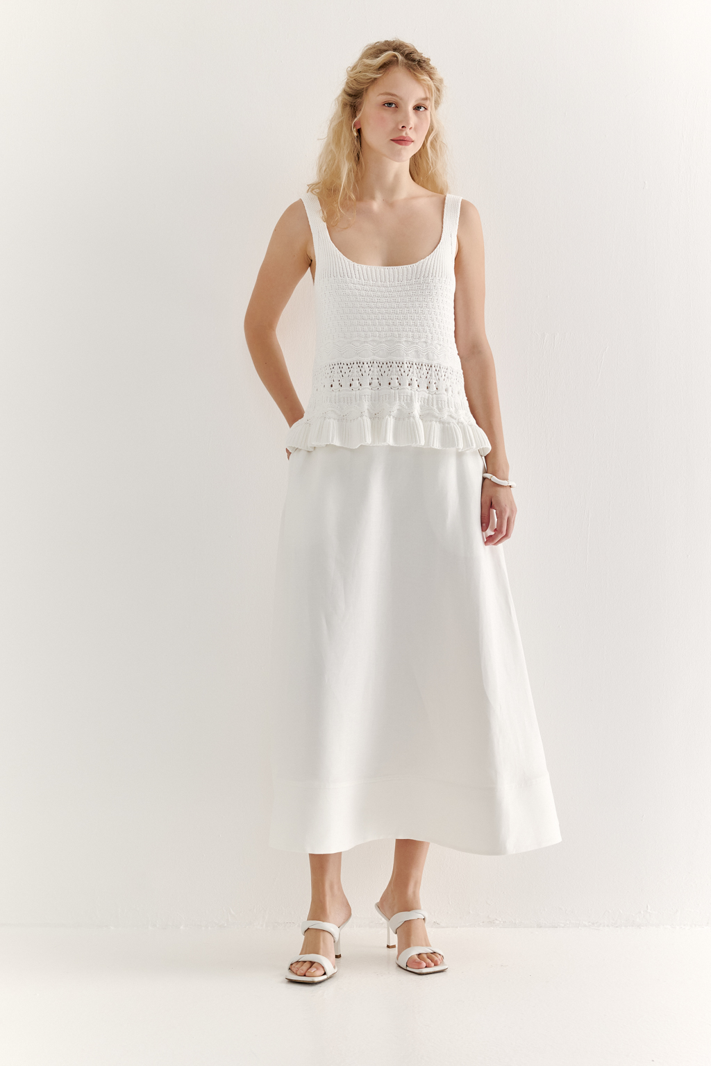 Топ из объёмной хлопковой пряжи с комбинированной крупнофактурной вязкой, с отделкой низа рюшем. Цвет-белый.