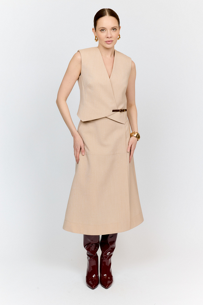 Укороченный жилет полуприлегающего силуэта приталенного кроя с функциональным и декоративным ремешком сбоку из 100% костюмной шерсти бежевого цвета - мастхев любого гардероба. С таким изделием легко собрать множество интересных многослойных и тотал костюмных образов как в офис, так и на каждый день.