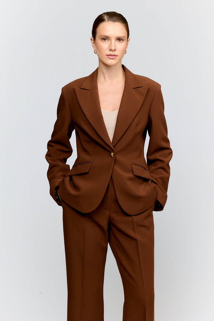 Базовый укороченный жакет из костюмной ткани в классическом древесном цвете. Острый английский воротник и лаконичная застёжка на одну пуговицу создают безупречный силуэт. Длина выше бёдер делает модель универсальной для деловых образов.