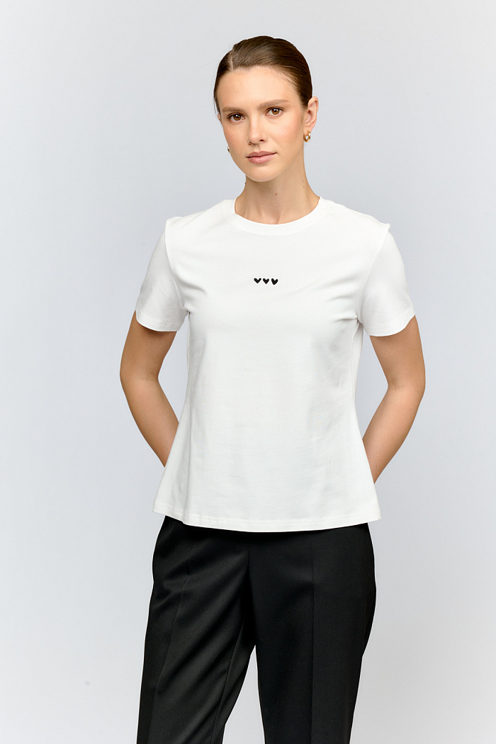 Трендовая футболка с вышивкой сердец, укороченная модель прилегающего силуэта из молочного хлопка.  Универсальный молочный цвет и минималистичный декор делают футболку стильным базовым элементом гардероба.