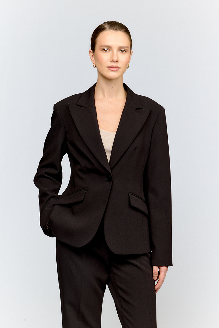 Базовый укороченный жакет из костюмной ткани в классическом чёрном цвете. Острый английский воротник и лаконичная застёжка на одну пуговицу создают безупречный силуэт. Длина выше бёдер делает модель универсальной для деловых образов.