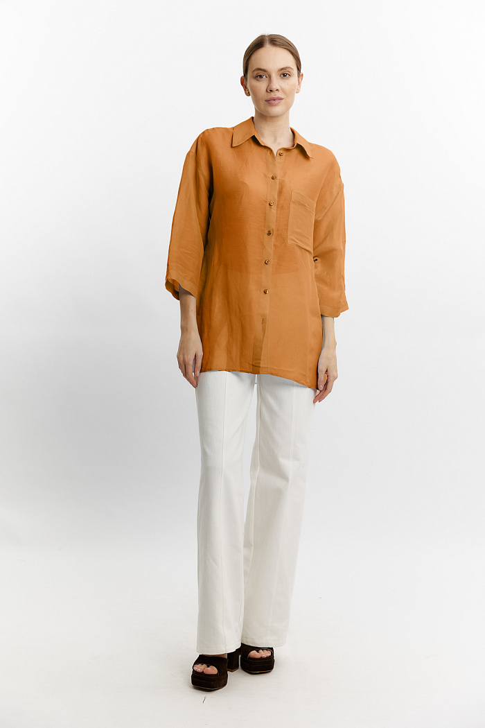 Блуза объемного кроя с одним накладным карманом. Застежка на пуговицах.