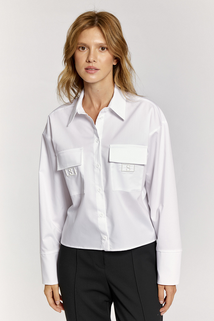 Блуза длиной до талии с накладными карманами и декоративной вышивкой.