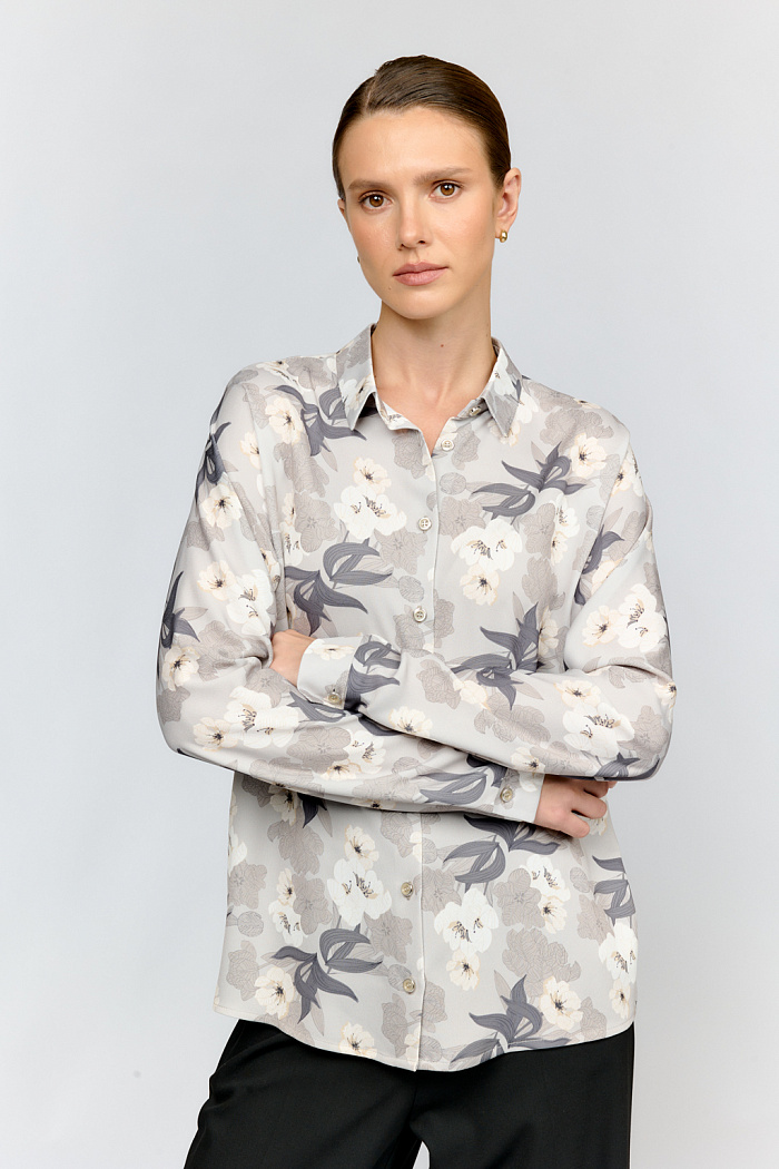 Нежная блуза серо - молочного оттенка с изысканным жемчужным сиянием и утончённым цветочным узором. Элегантные цельнокроеные рукава и изящная застёжка создают безупречный силуэт. Подходит для женственных образов с юбками и брюками.