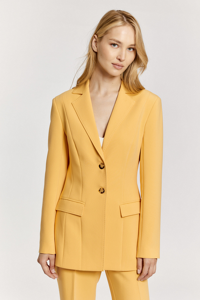 Жакет с расширенной линией плеча и прилегающий в талии, с застежкой на две пуговицы и английским воротником. Длина до середины бедер.