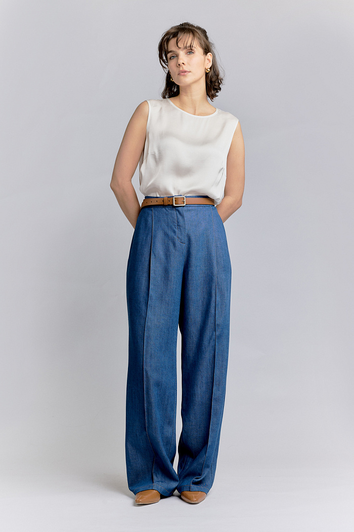 Брюки прямого кроя с защипами и двумя накладными карманами сзади. Застежка на пуговицу и молнию. Карманы в боковых швах