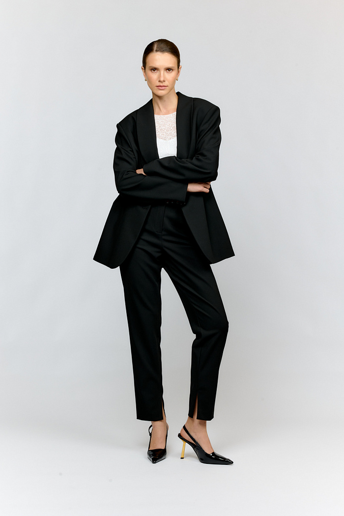 Укороченные брюки из премиальной костюмной ткани чёрного цвета — отличное решение для современного гардероба. Зауженный силуэт, мини разрезы на внутренней стороне брючин и стандартная посадка создадут универсальный вариант для стилизации. Идеально сочетаются с жакетом из такой же ткани, трикотажными кардиганами, элегантными лодочками и строгими аксессуарами.