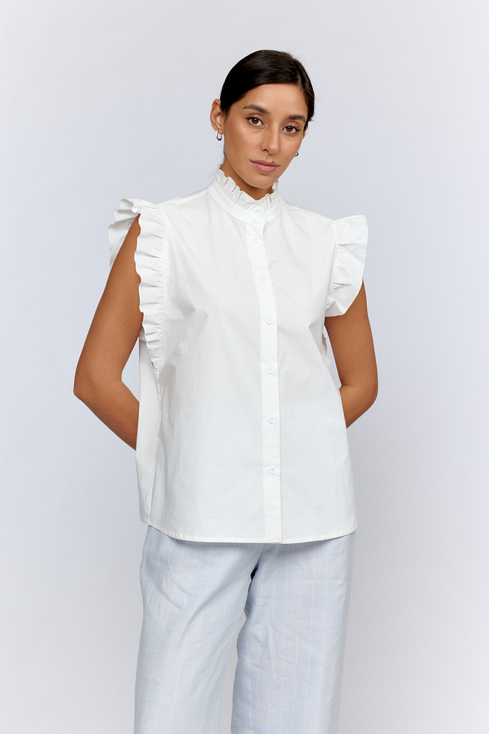 Блуза романтичная прямого силуэта с коротким рукавом с застежкой на пуговицах.Воротник стойка и рукава, с рюшами.