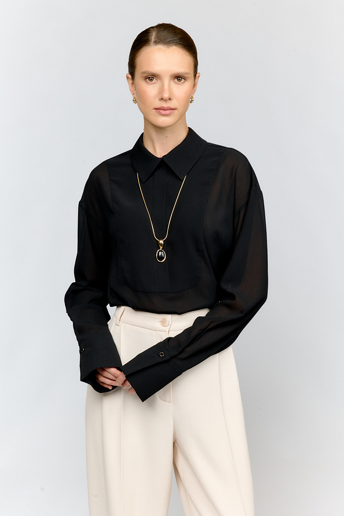 Полупрозрачная блуза прямого силуэта из крэш шифона черного цвета — воздушная и комфортная модель для носки в любой сезон. Фигурная кокетка на полочке  - главная деталь изделия. комбинируйте с юбками карандашами,широкими брюками и джинсами.