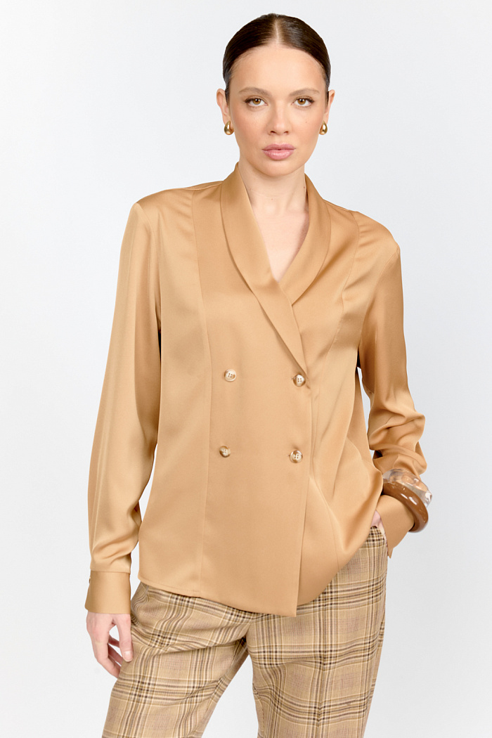 Двубортная блузка свободного кроя из струящейся блузочной ткани в осеннем теплом оттенке кэмел, с шалевым воротником, с разрезами по бокам. Может сочетаться с юбками и брюками из коллекции и носиться навыпуск и под заправку.