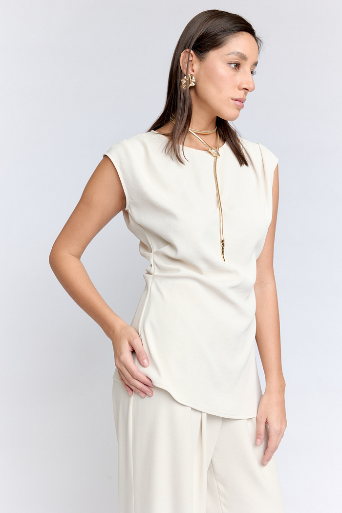 Асимметричный топ приталенного силуэта подчеркнет  женственные формы и скроет недостатки. Модель идеально впишется как в повседневные образы, так и для случаев, когда нужно добавить "изящности". Выполнена из приятной тактильно ткани с эластаном.