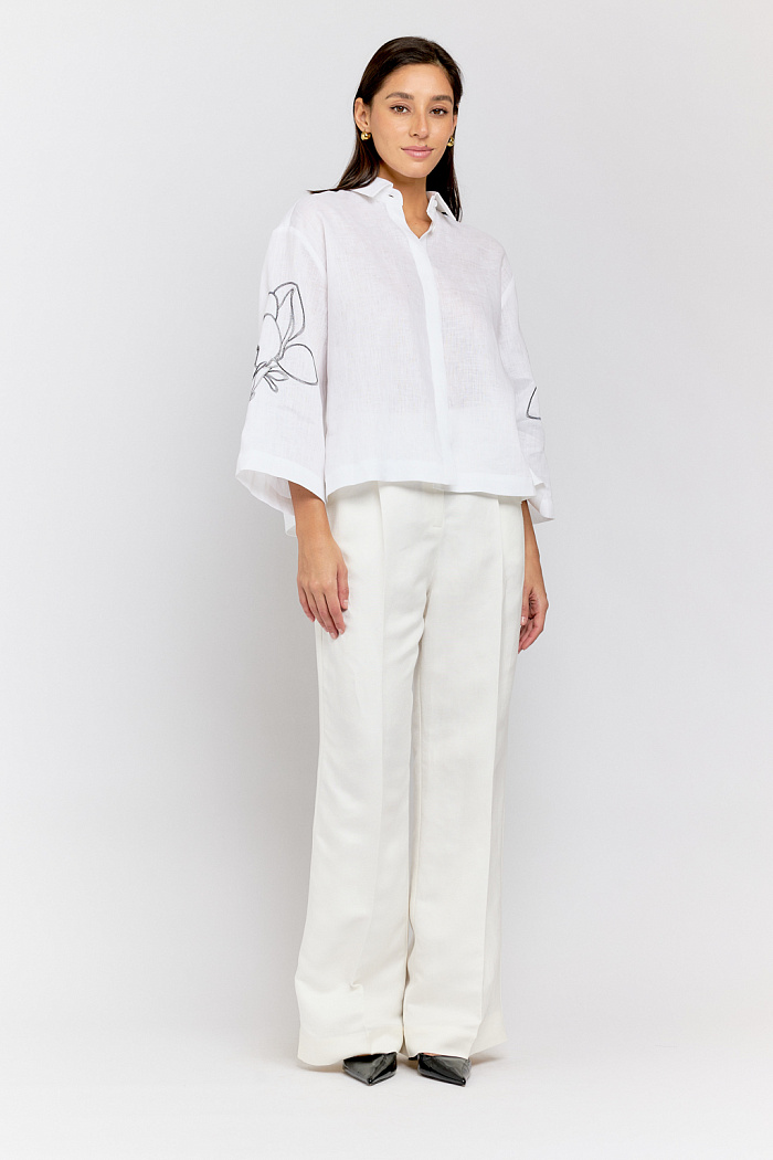 Блуза свободного кроя и рукавом 7/8. На рукавах вышивка "цветы".