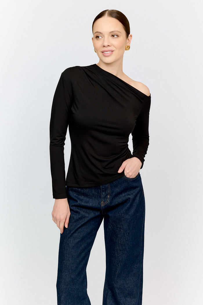 Лонгслив черного цвета с асимметричной горловиной и сборкой по плечевому шву из натуральной ткани. Изделие подарит приятные тактильные ощущения в носке. Подойдет для стилизации со множеством образов.