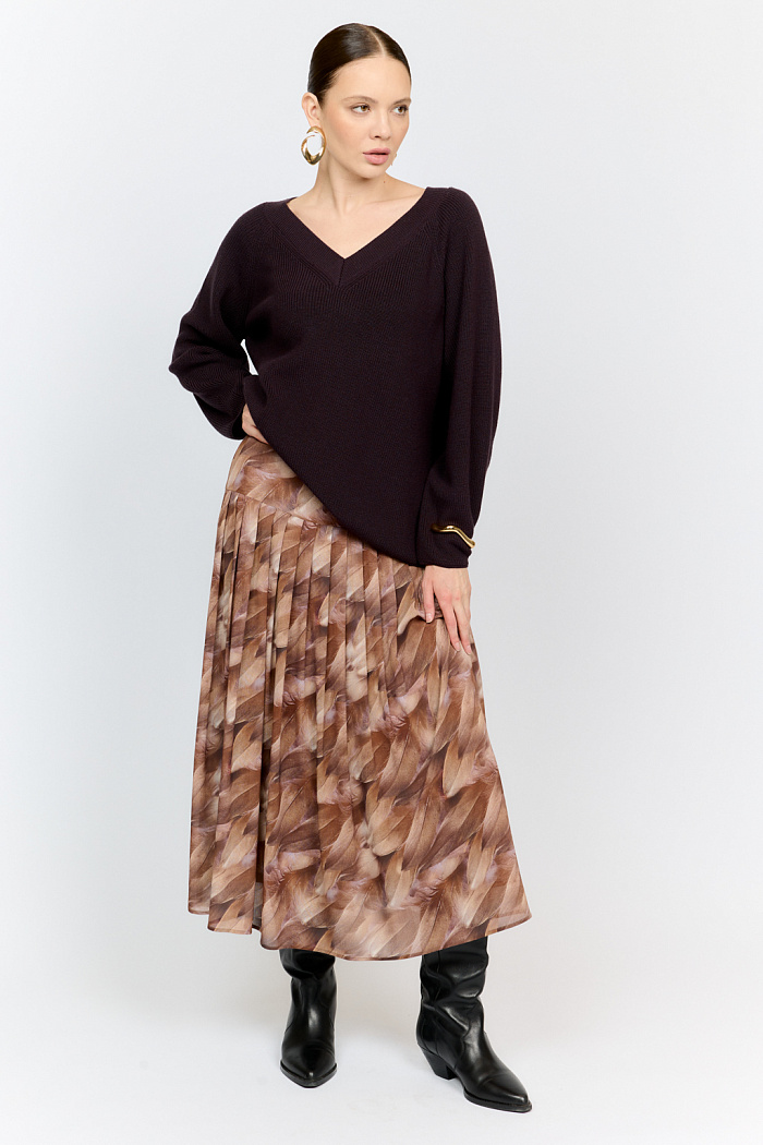 Трикотажный джемпер трендового черничного цвета свободного силуэта с V-образным вырезом горловины и рукавами реглан из шерстяной смесовой пряжи станет центром комфортных осенних образов.