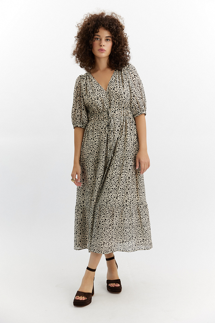 Свободного силуэта платье с рукавами на сборке, вырез горловины V-образный, объём по талии регулируется кулисами. Юбка ярусная, длина миди.