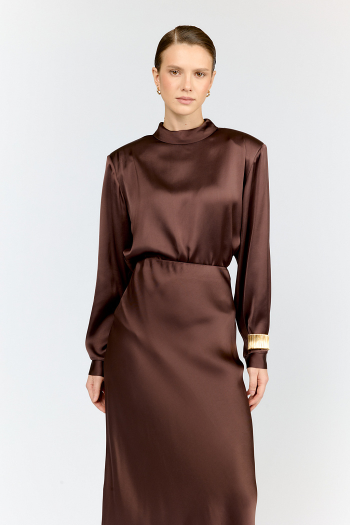 Стильная блуза прямого кроя с выразительными подплечиками и элегантной стойкой-горловиной — must-have для тех, кто ценит безупречный стиль! Благородный шоколадный оттенок с деликатным матовым переливом создаёт роскошный образ, а современный прямой силуэт с продуманными деталями подчёркивает фигуру.