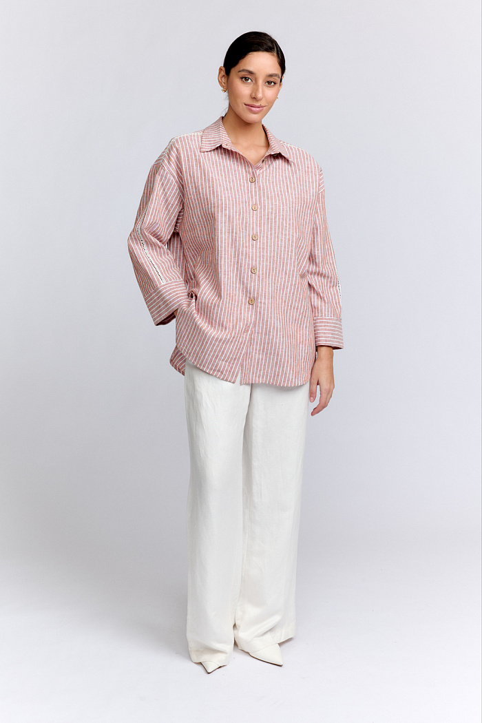 Рубашка свободного силуэта с рукавами длиной 7/8. Застежка на пуговицах. Рукава декорированы тесьмой.