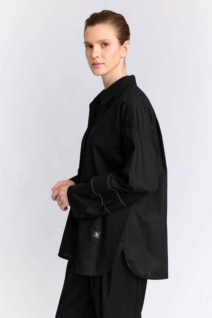 Блуза оверсайз силуэта с декоративными манжетами и контрастной строчкой.