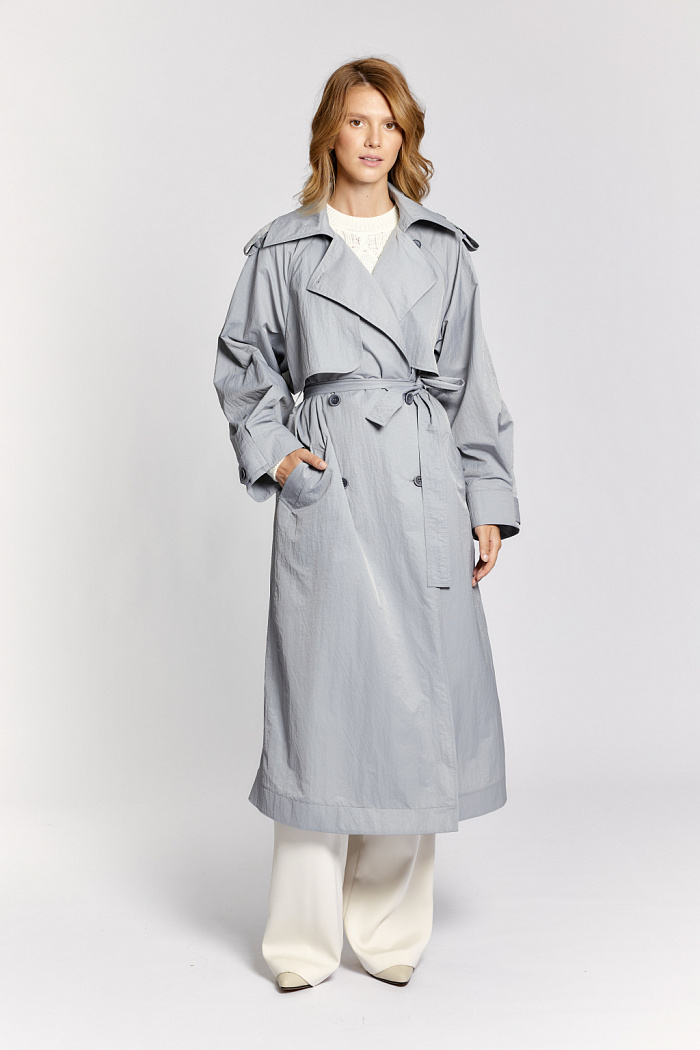 Двубортный плащ оверсайз силуэта с отлитыми кокетками и рукавами реглан. Длина миди. Приталивается поясом.