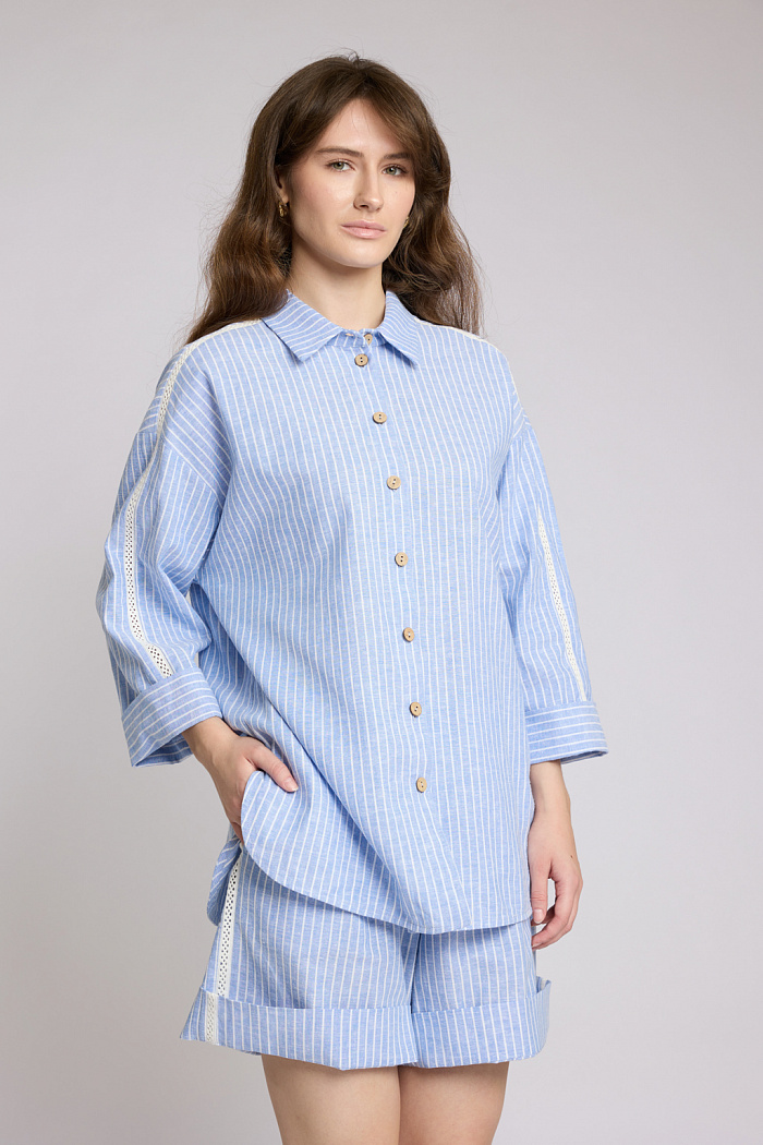 Рубашка свободного силуэта с рукавами длиной 7/8. Застежка на пуговицах. Рукава декорированы тесьмой.