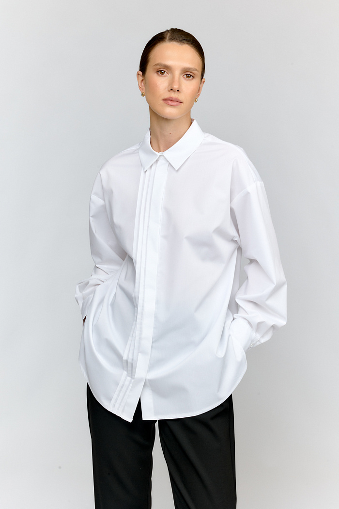 Стильная рубашка в свободном оверсайз-силуэте из премиального блузочного хлопка белого цвета. Модель привлекает внимание элегантными застроченными складками по полочке. Комфортный крой позволяет носить рубашку как в офисном ансамбле, так и в повседневных образах.
Хлопковая ткань обеспечивает отличную посадку и приятные тактильные ощущения. Свободный силуэт и продуманный крой делают рубашку идеальной базой для создания многослойных образов.