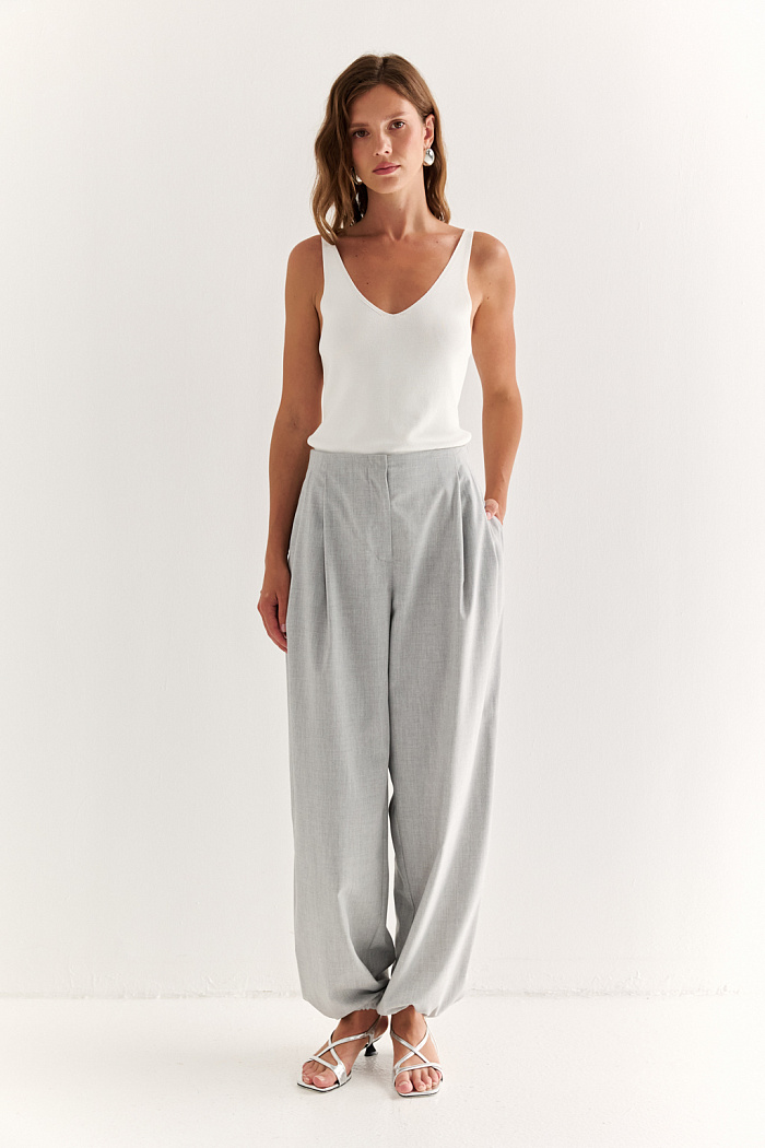 Брюки с резинкой по низу: стиль вне формата. Свободные брюки с объёмом по бедру и эластичной сборкой у щиколоток — комфорт и энергия в каждом шаге. Они повторяют эстетику спортивного силуэта, но остаются верны элегантности благодаря продуманным деталям: вытачкам, аккуратному поясу и чистой линии посадки. Идеально сочетаются с укороченной рубашкой-курткой, футболками или приталенными топами, позволяя играть с объёмом и балансом образа. Подходят как для активного дня, так и для расслабленных городских выходов. Брюки, которые подстраиваются под ваш ритм.