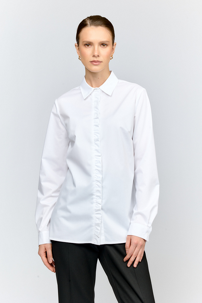 Рубашка из смесового хлопка в белом цвете с  декоративной рюшей по центру. Классический прямой силуэт и застёжка на пуговицы делают модель универсальной базой для любого образа.